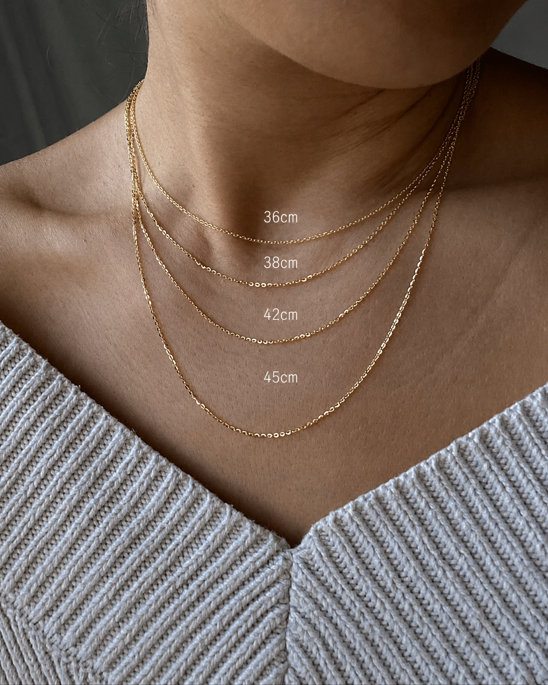 Gold necklace displayed on a person's neck with measurements indicated.